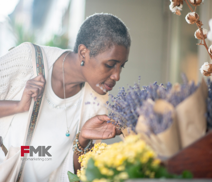 Mujer oliendo flores en una tienda, marketing sensorial